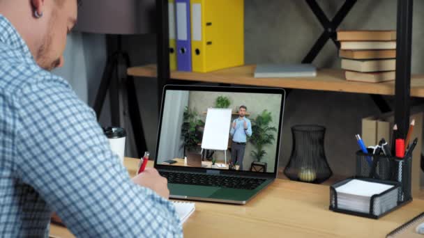 Бизнесмен в офисе изучает онлайн бизнес-курс ноутбука, пишет в ноутбуке — стоковое видео