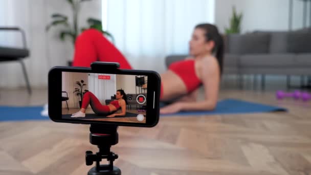 Mulher de esportes fitness blogger registra aula de curso on-line no smartphone em casa — Vídeo de Stock