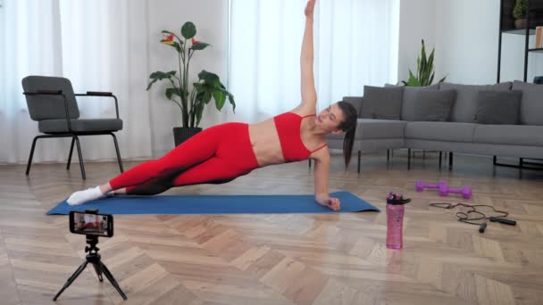 Fit femme entraîneur de conditionnement physique blogueur dit enseigne à l'élève faire de l'exercice de planche — Video