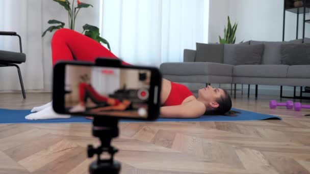 Fit vrouw fitness trainer doen oefening gluteal brug terwijl liggend op yoga mat — Stockvideo