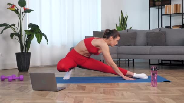 Formda bir kadın yoga ya da spor paspası üzerinde ısınma egzersizi yapıyor. — Stok video