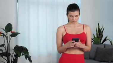 Portrait sportswoman looking at smartphone social network media after training