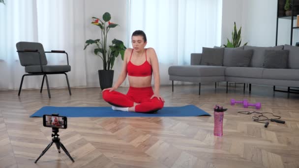 Mujer del deporte graba en línea clase magistral lección en el teléfono inteligente en casa — Vídeos de Stock