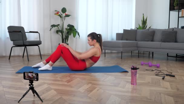 Блогер Fit женщина фитнес-тренер говорит учит студента делать упражнения брюшной полости — стоковое видео