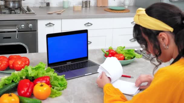 Ноутбук с голубым экраном: Женщина говорить шеф-повар учитель поиск кулинарный рецепт в ноутбуке — стоковое видео