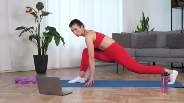 Fit vrouw kijken online sport webinar laptop, doen warming-up stretching training — Stockvideo