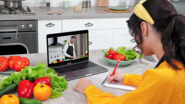 Mujer en cocina estudio curso de cocina en línea escuchar profesor le dice a la computadora portátil chef — Vídeos de Stock