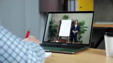 İşadamı deftere yazıyor, online eğitim işletme dersi laptopu okuyor.
