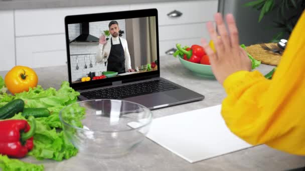 Woman housewife greets listen chef slices cucumber, watch online cooking course — Stock Video
