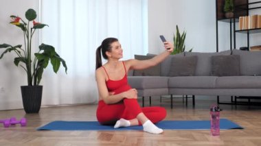 Gülümseyen kadın fitness blogcusu Selfie kamera akıllı telefonunu dinletiyor