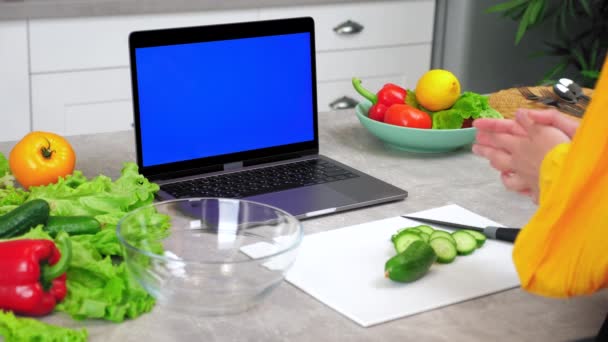 Portátil de pantalla azul: Mujer en saludos de cocina le dice al chef escuchar rodajas de pepino — Vídeo de stock