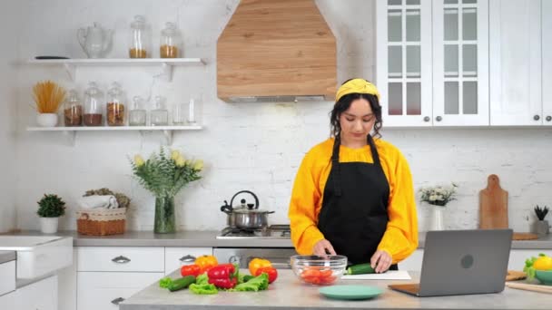 Жінка скибочки огірка слухати вчителя шеф-кухаря вивчати онлайн відео виклик веб-камери ноутбук — стокове відео