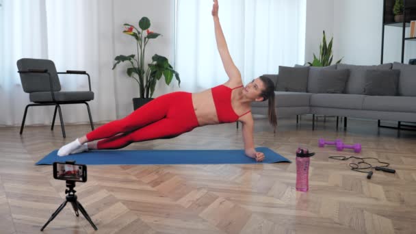 Fit vrouw fitness trainer blogger vertelt doceert student doen plank oefening — Stockvideo