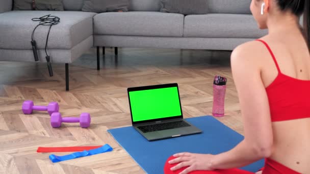 Ordenador portátil de pantalla verde: mujer Fit mira portátil dice escuchar entrenador de fitness en línea — Vídeo de stock
