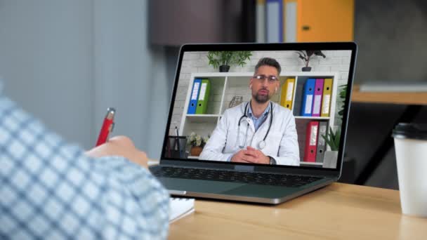 Dizüstü bilgisayardaki adam doktor uzak çevrimiçi video arama web kamerasına danışıyor — Stok video