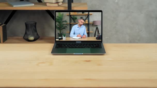 笔记本电脑站在一个空的桌子显示器上，上面有一个男生在笔记本上写字 — 图库视频影像