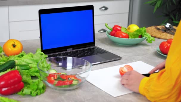 Laptop tela azul: Mulher em fatias de cozinha pepino na placa de corte diz chef — Vídeo de Stock