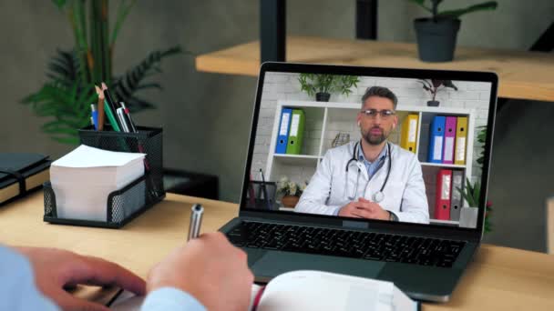 Чоловік лікар в екрані ноутбука розповідає консультації онлайн відео виклик комп'ютерної веб-камери — стокове відео