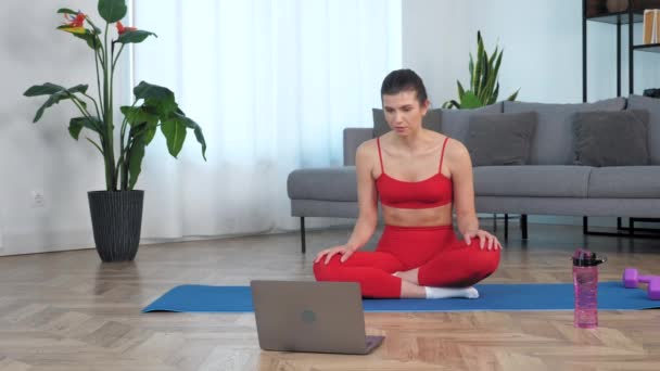 Formda bir kadın fitness eğitmenine online video çalışmasını, web cam dizüstü bilgisayar aramasını söyler — Stok video