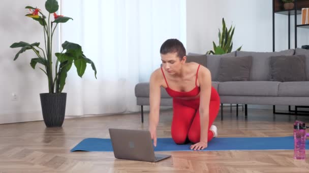 Woman in sportswear doing warm-up before workout exercise on yoga fitness mat — Video