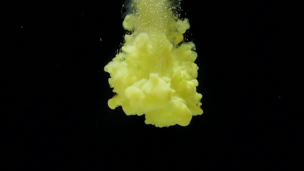 Ink in water. Slow motion yellow ink acrylic paint drops in water and mixes — Stock Video