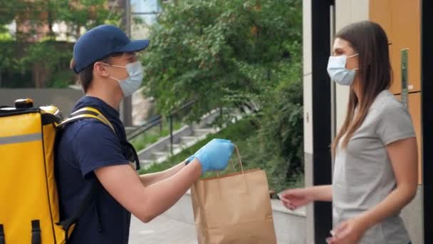 Consegna uomo indossa maschera e guanti per consegnare ordine mascherato cliente donna — Video Stock