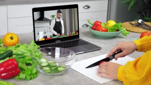 Man food blogger in laptop screen tells teaches housewife remote cooking course — Stock Video