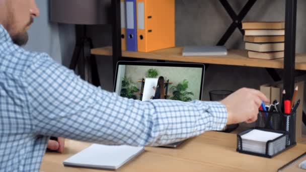 Бізнесмен в офісі вивчає бізнес онлайн-курс ноутбук, пише в блокноті — стокове відео