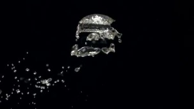 Sudaki yavaş çekim hava kabarcıkları siyah arkaplanda yüzeye yükseliyor