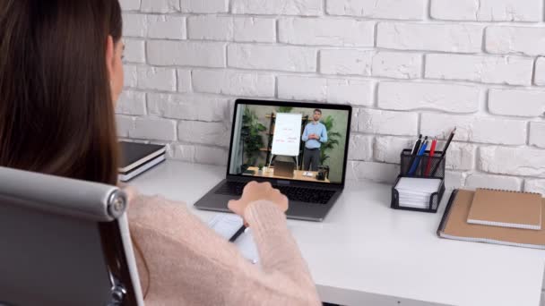 Bizneswoman w biurze domu wita słuchać rozmów wideo online, pisze w notebooku — Wideo stockowe