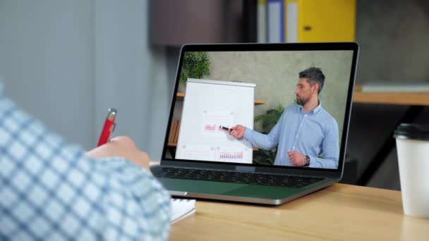 Mann studieren Online-Business-Webinar Laptop, schreibt in Notizbuch zuhören Lehrer — Stockvideo