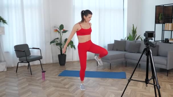 Apto mulher forte treinador de fitness blogger fazendo agachamento treino de exercício em casa — Vídeo de Stock