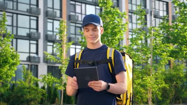 外型面带微笑的男人带着热背包送餐用平板电脑 — 图库视频影像