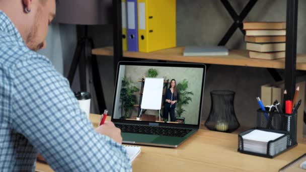 Empresário em estudo em casa assistir webinar de negócios on-line, escreve em notebook — Vídeo de Stock
