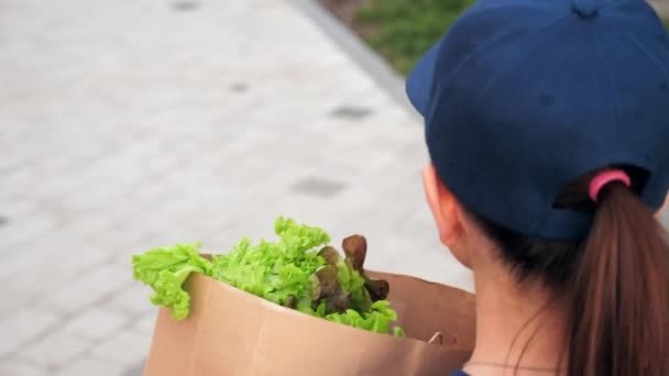 Voedsel levering vrouw koerier met papieren zak boodschappen om bestelling klant te leveren — Stockvideo