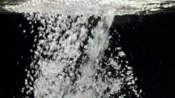 Proud vody kapky dolů v akváriu na černém pozadí — Stock video