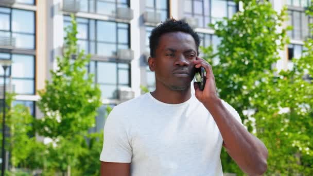 Ritratto uomo afro-americano in t-shirt che parla sul cellulare bevendo caffè — Video Stock