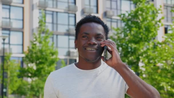 Retrato sonriente afroamericano hablando por teléfono móvil bebiendo café — Vídeo de stock