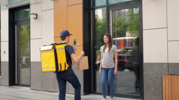 Smiling food delivery mensajero hombre con mochila térmica entregar orden mujer — Vídeos de Stock