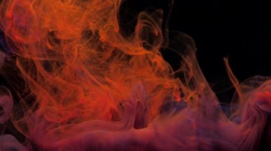 Kırmızı turuncu ve mor mürekkep suyun içinde karışır, suyun altında hafifçe döner.