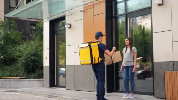 Corriere uomo consegna cibo positivo con zaino termico consegnare ordine donna — Video Stock