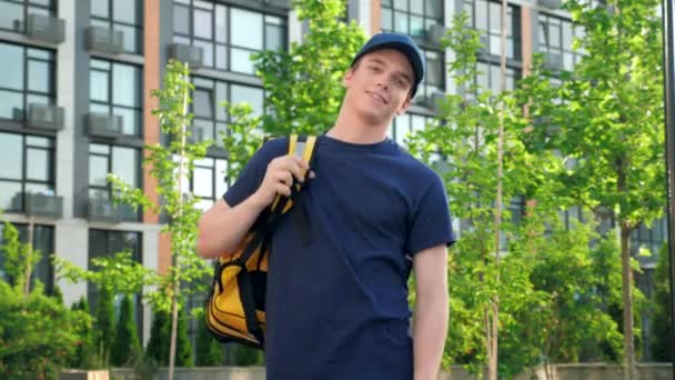 Retrato hombre sonriente mensajero comida entrega pone en mochila térmica se ve cámara — Vídeos de Stock