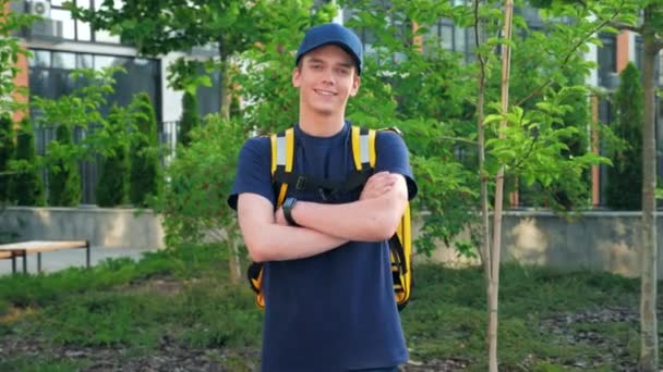 Fényképezőgép zoom mosolygós fiatalember futár élelmiszer szállítás termál hátizsák — Stock videók