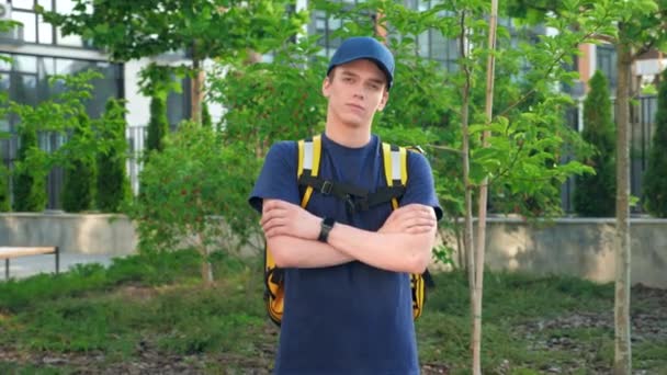 Přiblížit dodávky potravin mladý muž kurýr s termální batoh kříže ruce — Stock video