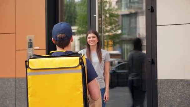 Позитивна доставка їжі чоловік кур'єр з термальним рюкзаком доставити замовлення жінка — стокове відео