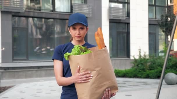 Food delivery woman courier with paper bag groceries to deliver order client — Stock Video