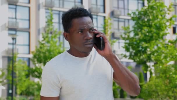 Portrét Afričan mluví na mobilním telefonu na pozadí moderní budovy — Stock video