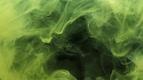 Green and yellow ink acrylic paint mixing in water, swirling softly underwater — Stock Video