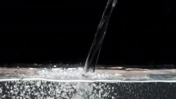 Ruisseau d'eau descend dans l'aquarium sur fond noir isolé — Video