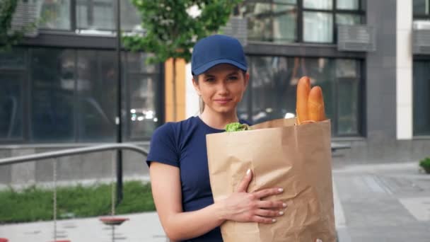 Retrato sorrindo entrega de alimentos mulher correio mantém saco de papel com mantimentos — Vídeo de Stock